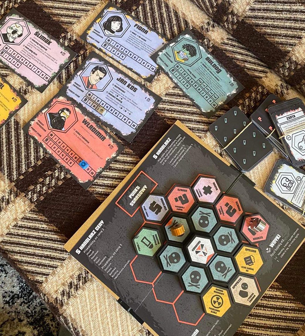 Complete Kombinat set with the rotating hex board, illustrated character sheets, cards, and tokens laid out together.