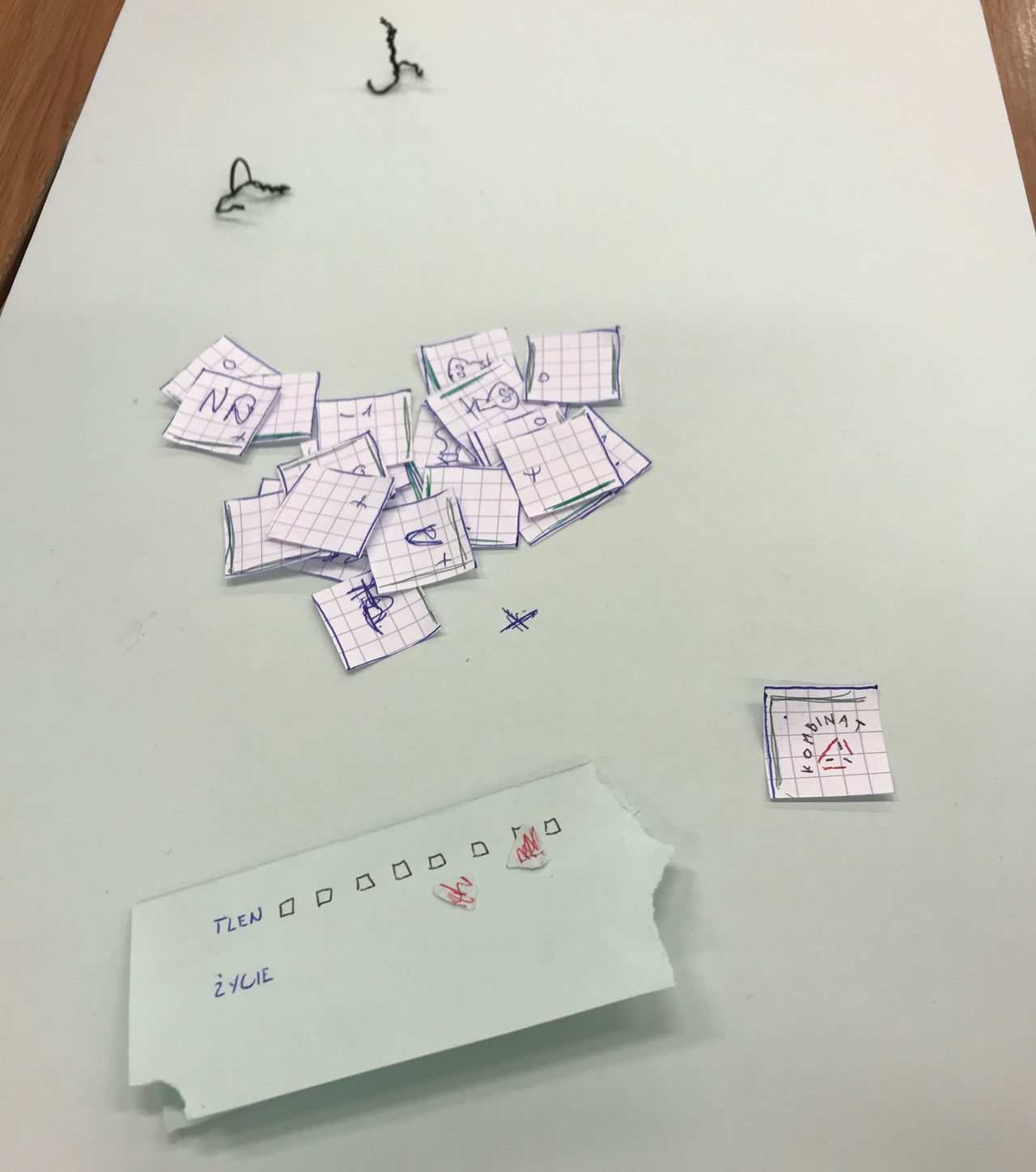 First paper prototype with hand-drawn cards, wire player pieces, and handwritten oxygen and health tracks.