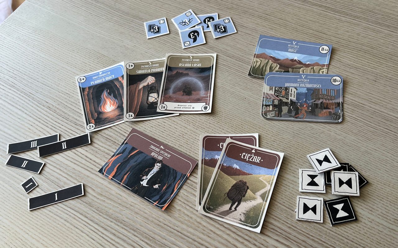 Illustrated ability, decision, Struggle, and Burden cards with turn and probability tokens arranged on a table.