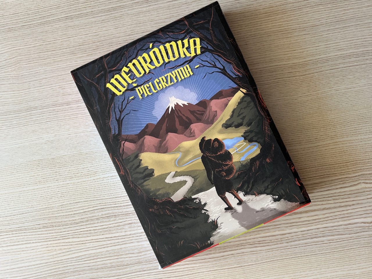 Illustrated Pilgrim prototype box showing a cloaked traveller walking toward a bright mountain.