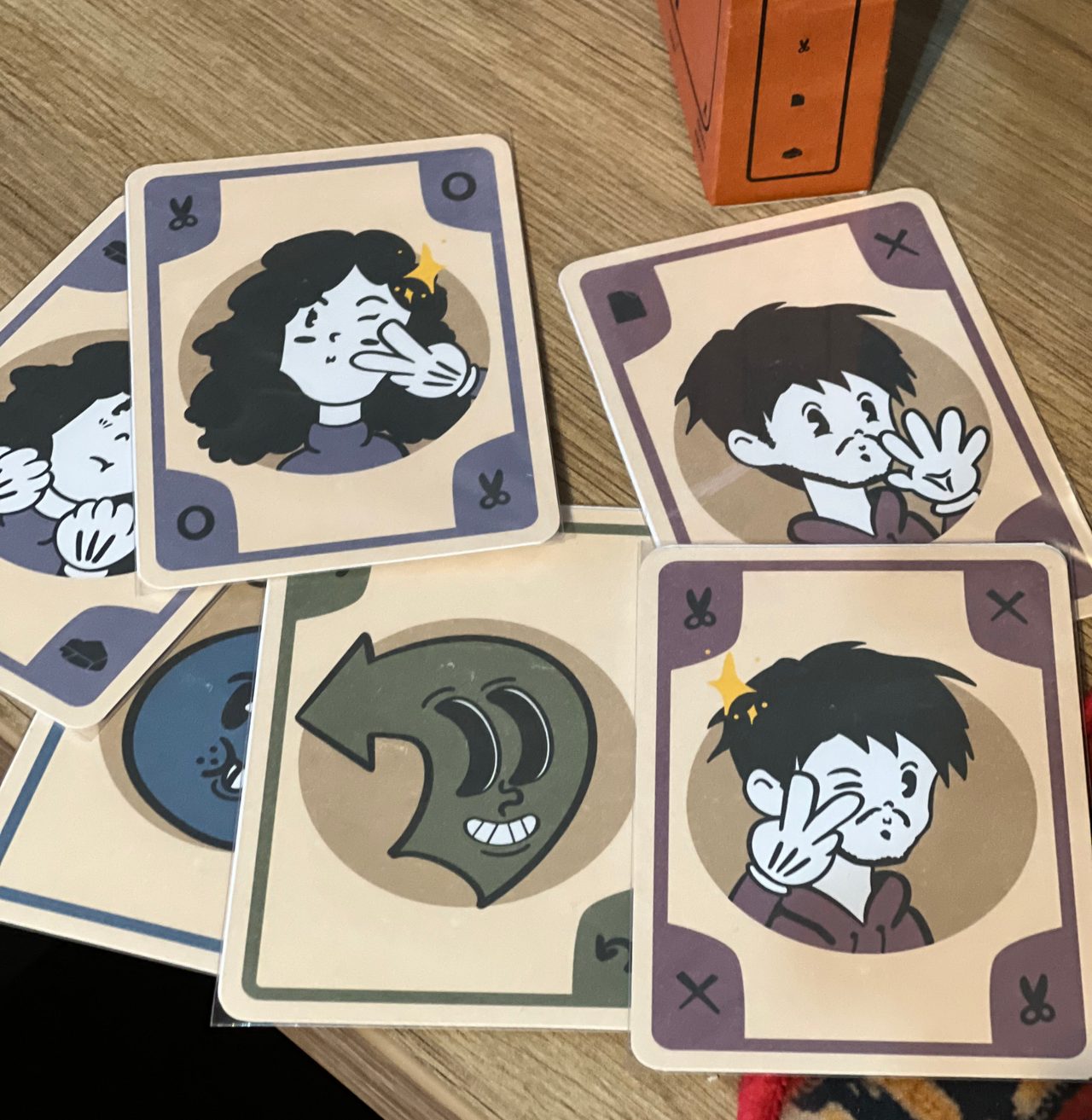 Close view of illustrated character and action cards marked with rock, paper, scissors, bomb, and undo symbols.